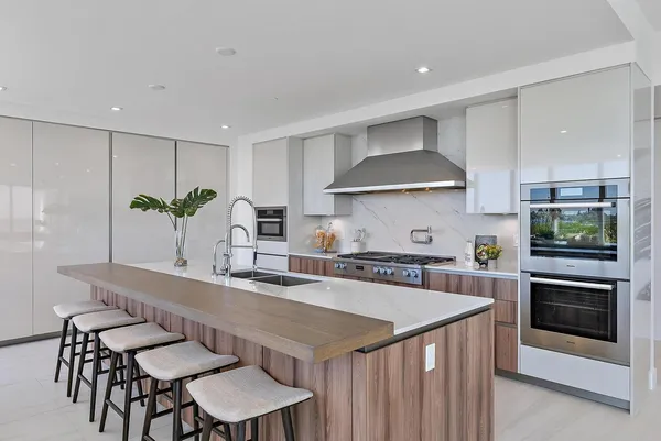 a kitchen with granite countertop a table chairs stove and cabinets