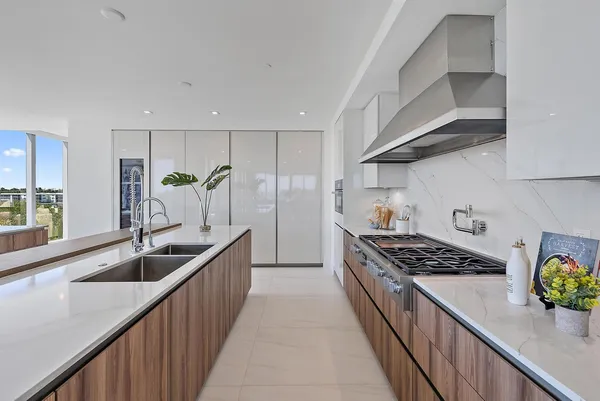 a kitchen with stainless steel appliances a sink stove and cabinets