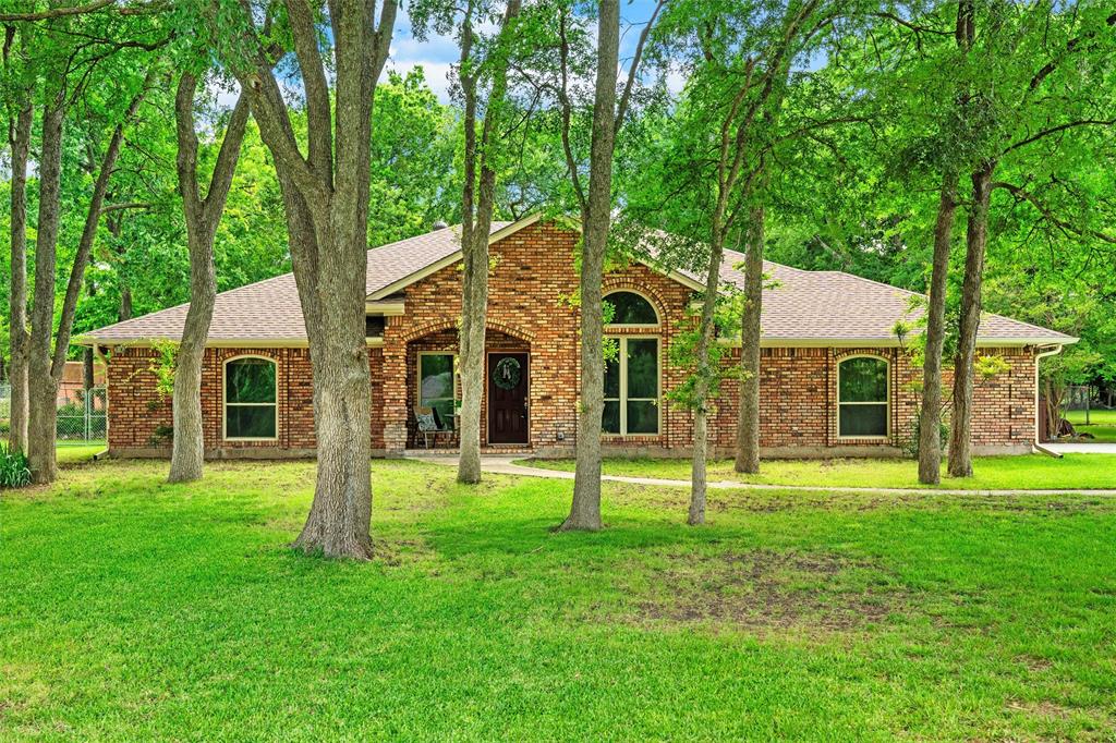 Brick exterior residence with a gabled roofline and an arched window accent