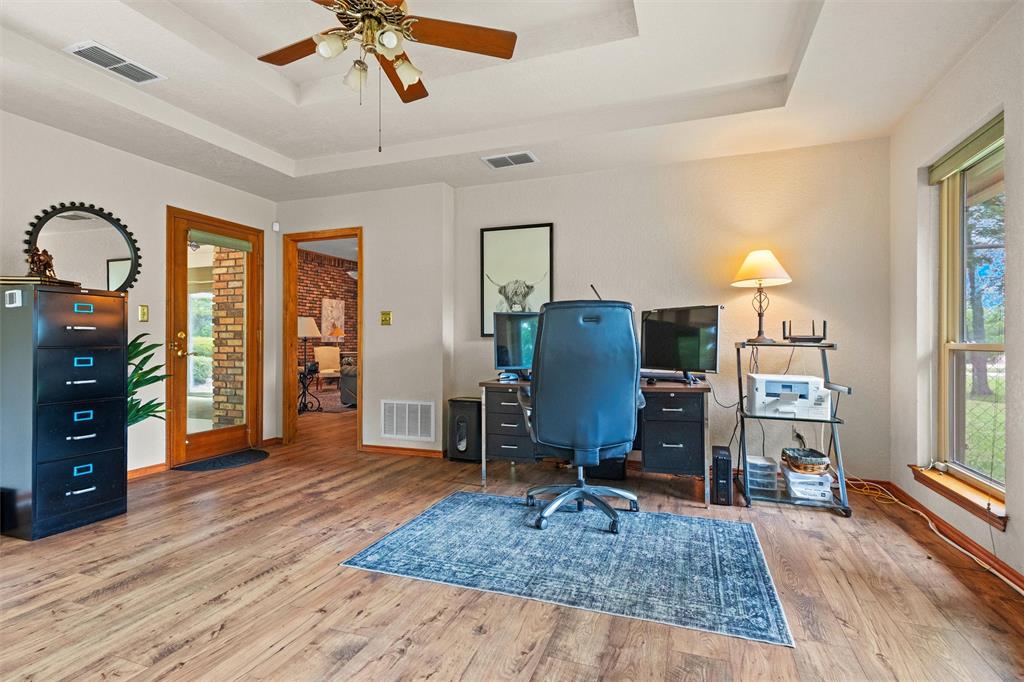 217 Valley Ranch Road Weatherford, TX 76087 - Photo 18 of 38 Versatile interior space featuring wood-finish flooring, a tray ceiling, and a ceiling fan