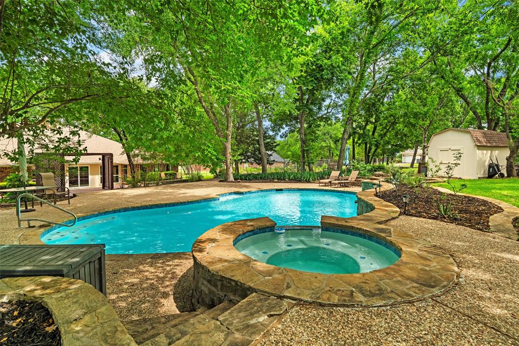 217 Valley Ranch Road Weatherford, TX 76087 - Photo 2 of 38 Freeform swimming pool and integrated spa with stone coping, surrounded by a textured concrete deck
