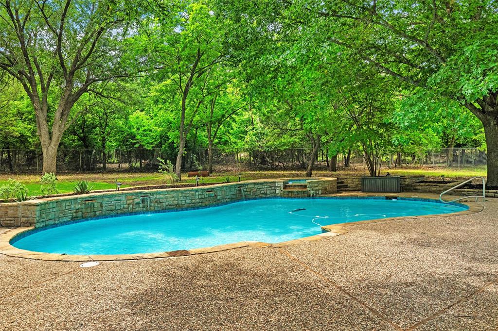 217 Valley Ranch Road Weatherford, TX 76087 - Photo 35 of 38 Freeform swimming pool with a stone coping and exposed aggregate decking