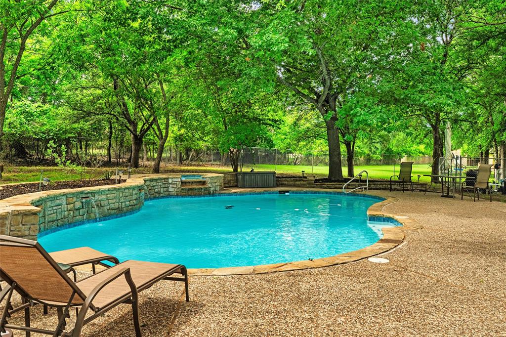 217 Valley Ranch Road Weatherford, TX 76087 - Photo 36 of 38 Curved inground pool featuring stone coping and a stone-clad raised spa