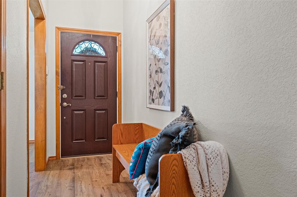 217 Valley Ranch Road Weatherford, TX 76087 - Photo 6 of 38 Entryway featuring a dark wood panel door with an arched decorative glass insert and brushed nickel hardware