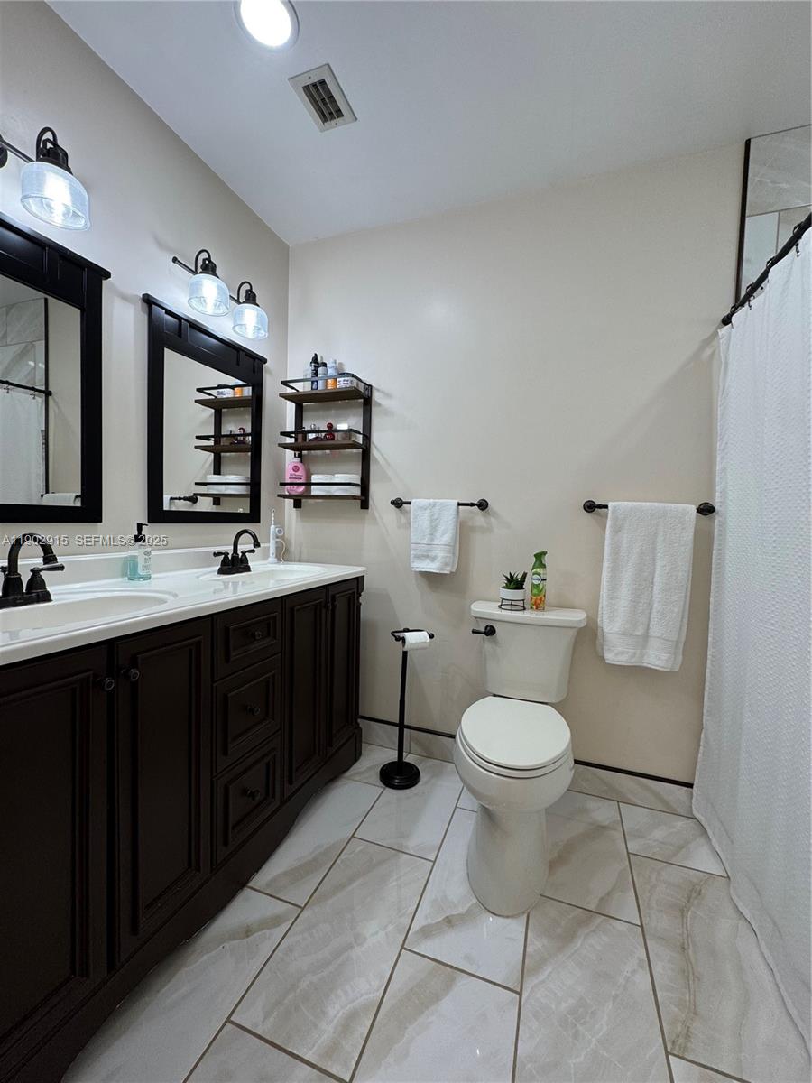 20440 Southwest 292nd Street Homestead, FL 33030 - Photo 19 of 57 a bathroom with a toilet sink and mirror