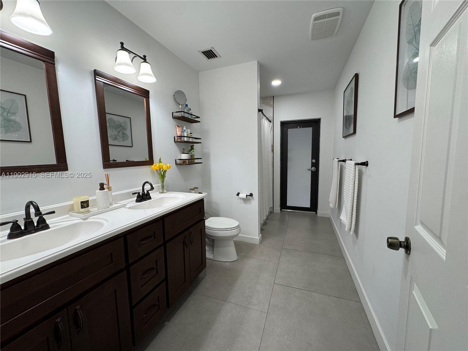 20440 Southwest 292nd Street Homestead, FL 33030 - Photo 29 of 57 a bathroom with a double vanity sink toilet and mirror
