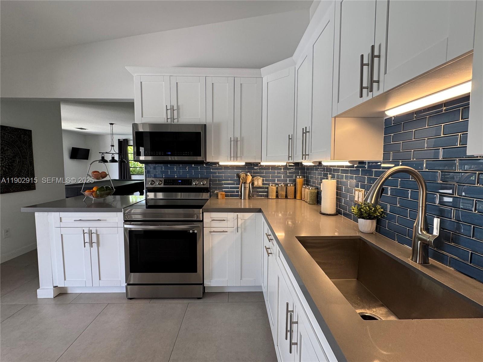 20440 Southwest 292nd Street Homestead, FL 33030 - Photo 40 of 57 a kitchen with stainless steel appliances granite countertop a sink and stove