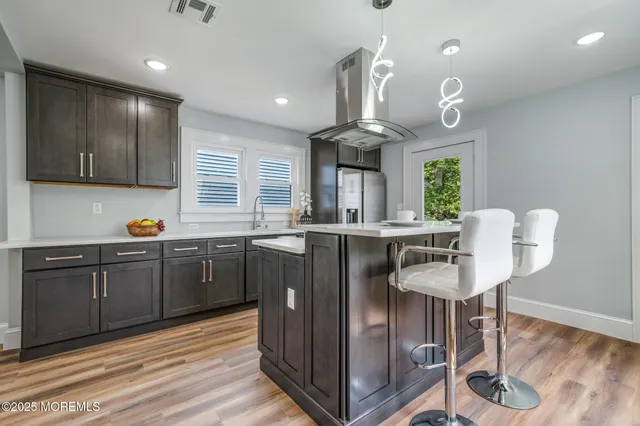 a kitchen with granite countertop a sink cabinets and wooden floor