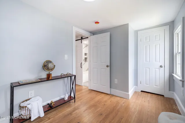 a view of a hallway with wooden floor and glass door