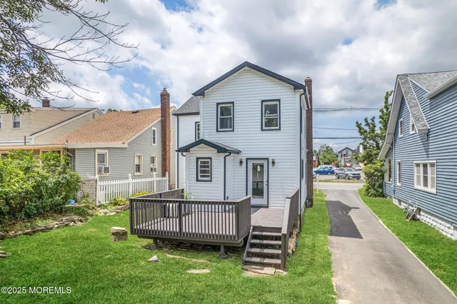 a view of a house with a yard and deck