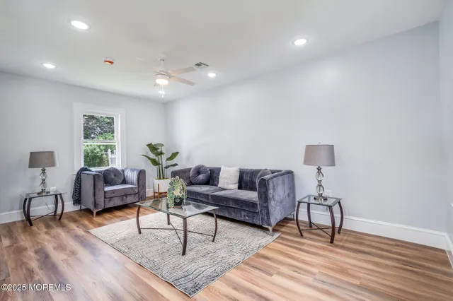 a living room with furniture and a wooden floor