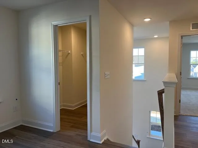 a view of a hallway with wooden floor and closet