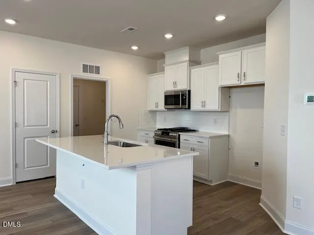 a kitchen with white cabinets and sink