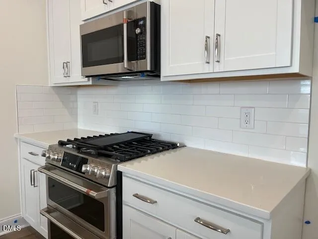 a kitchen with microwave cabinets and stove top oven