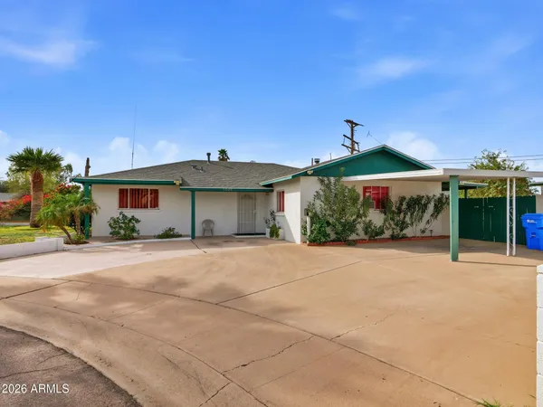 a view of a house with a yard and potted plants