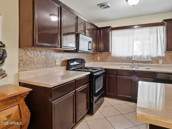 a kitchen with stainless steel appliances granite countertop a sink stove and cabinets