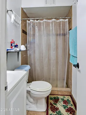 a bathroom with a toilet and a shower curtain