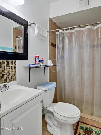 a bathroom with a sink a toilet and shower curtain