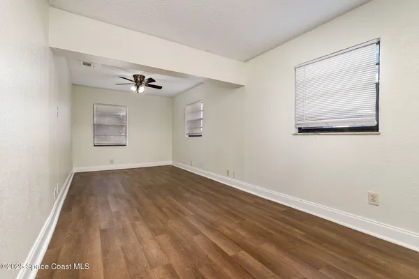 a view of a room with wooden floor and windows