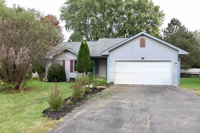 a view of a house with a small yard plants and large tree