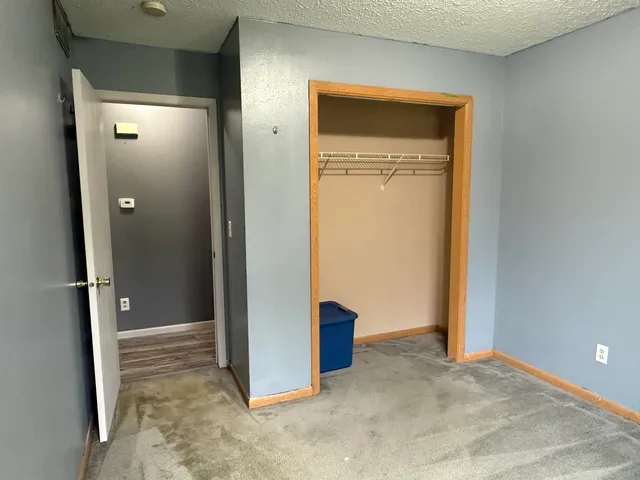 an empty room with closet and a door
