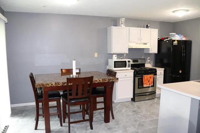 a dining room with a table chairs and a refrigerator