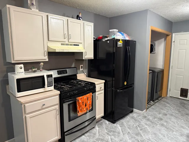 a kitchen with stainless steel appliances granite countertop a refrigerator stove and sink