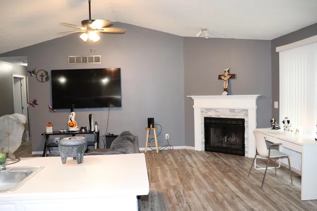 a living room with furniture a fireplace and a flat screen tv