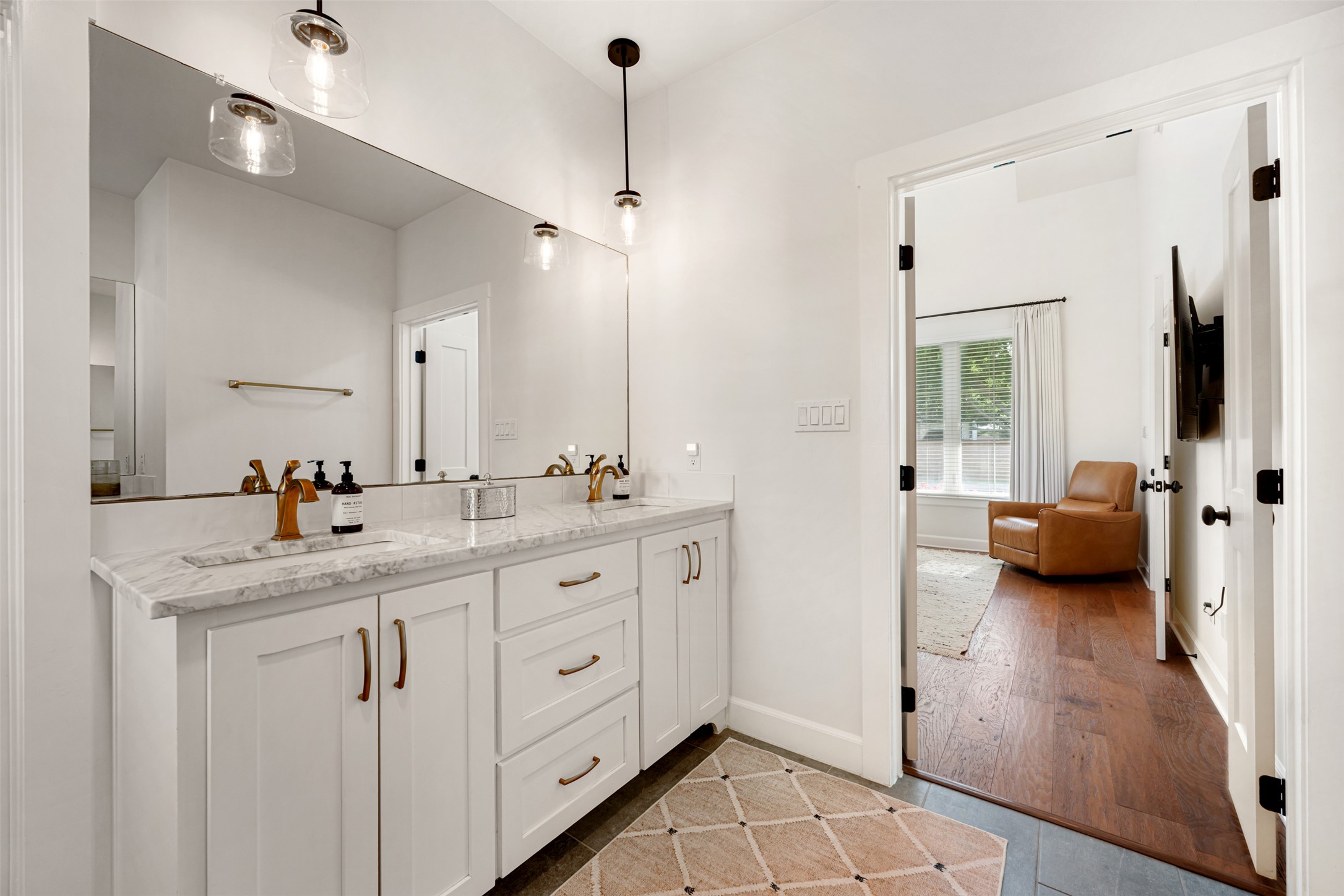1301 West Street Georgetown, TX 78626 - Photo 26 of 40 Marble countertops and brass fixtures elevate this well-appointed bathroom with dual vanities.