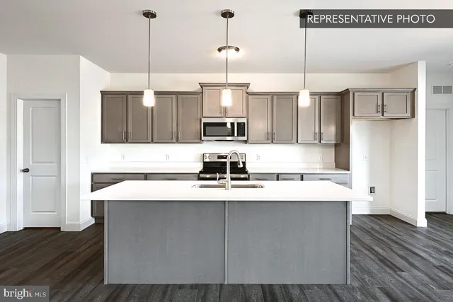 a kitchen with kitchen island granite countertop a sink a counter space appliances and cabinets