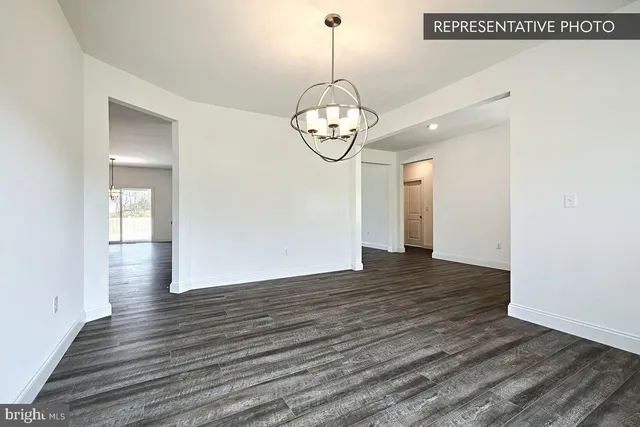 a view of a room with wooden floor and white walls