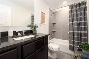 a bathroom with a granite countertop sink toilet a large mirror and shower