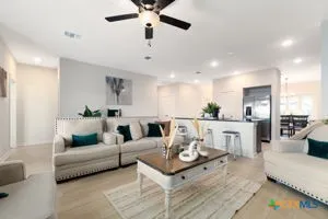 a living room with furniture and a view of kitchen