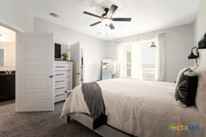 a bedroom with a bed and a ceiling fan