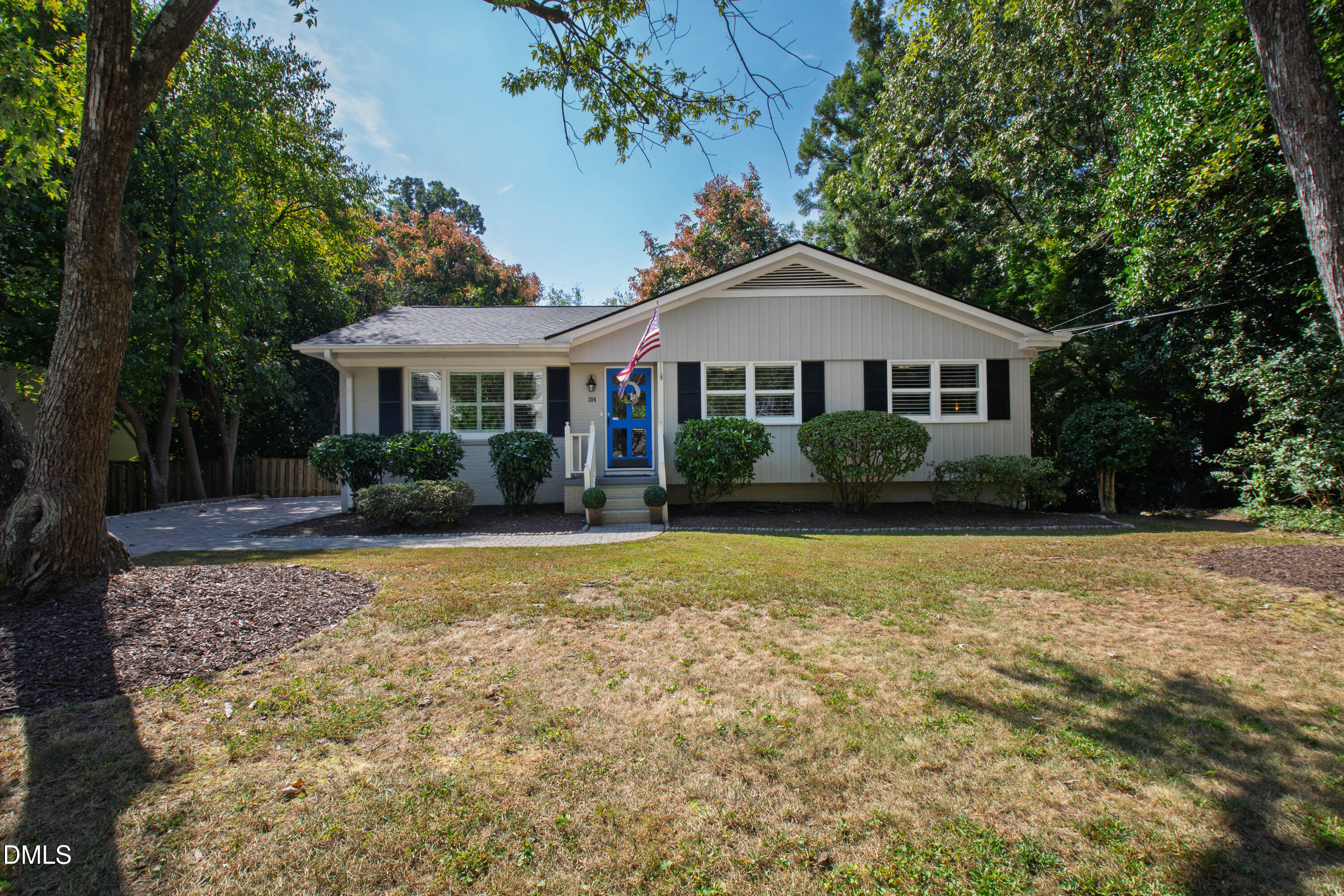 a front view of a house with a yard and trees