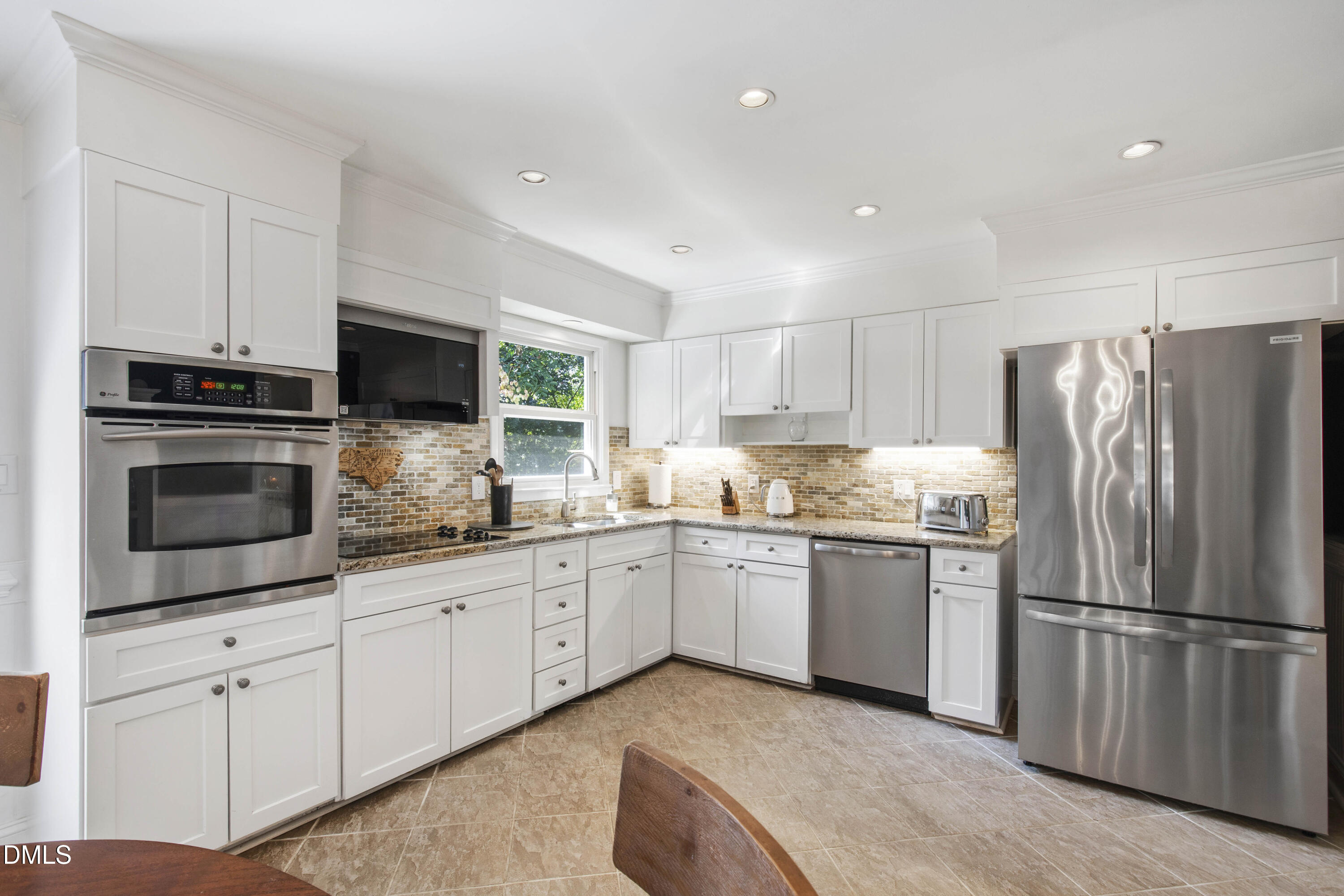 304 Latimer Road Raleigh, NC 27609 - Photo 19 of 42 a kitchen with granite countertop white cabinets and stainless steel appliances