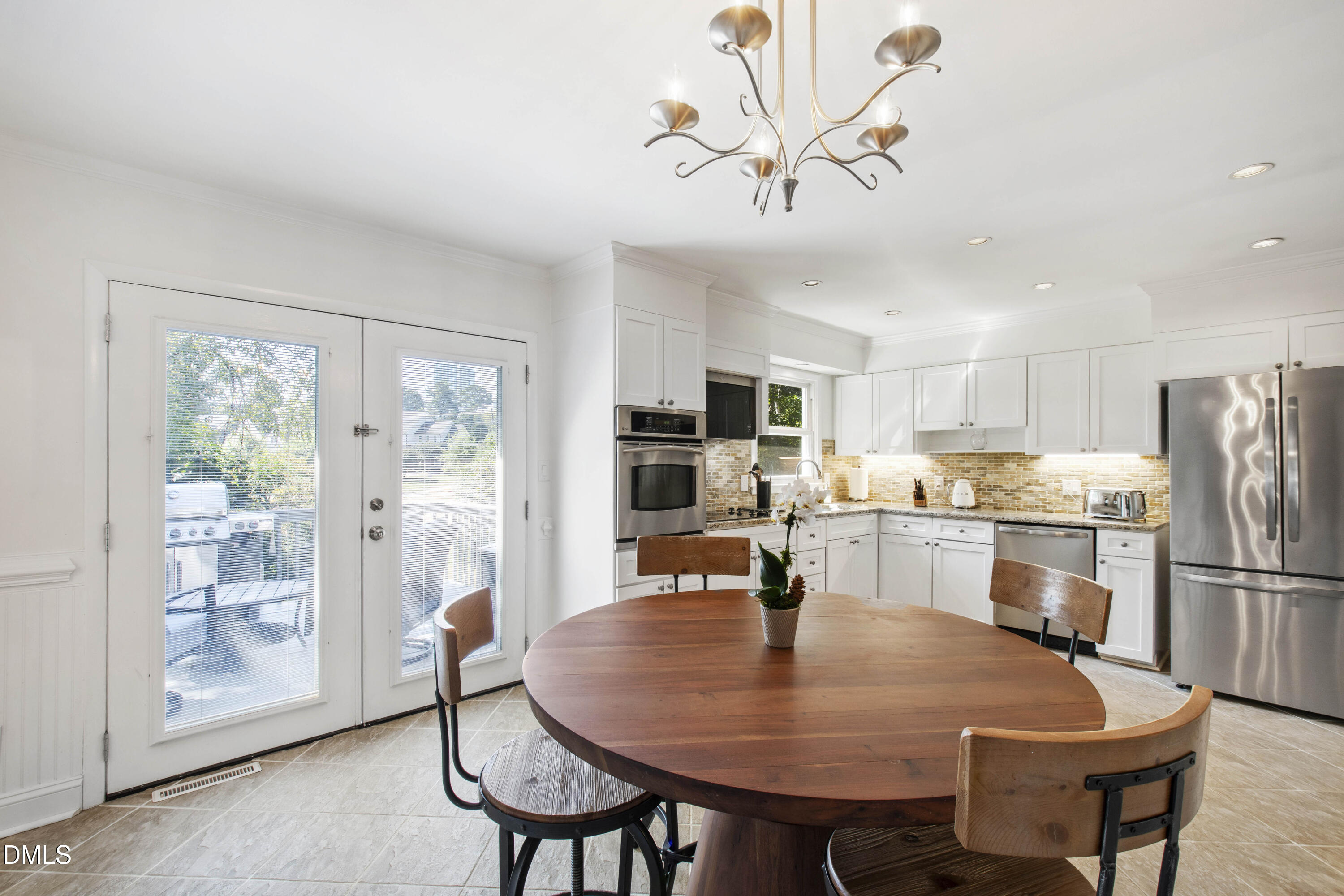 304 Latimer Road Raleigh, NC 27609 - Photo 22 of 42 a kitchen with stainless steel appliances granite countertop a dining table chairs refrigerator and cabinets