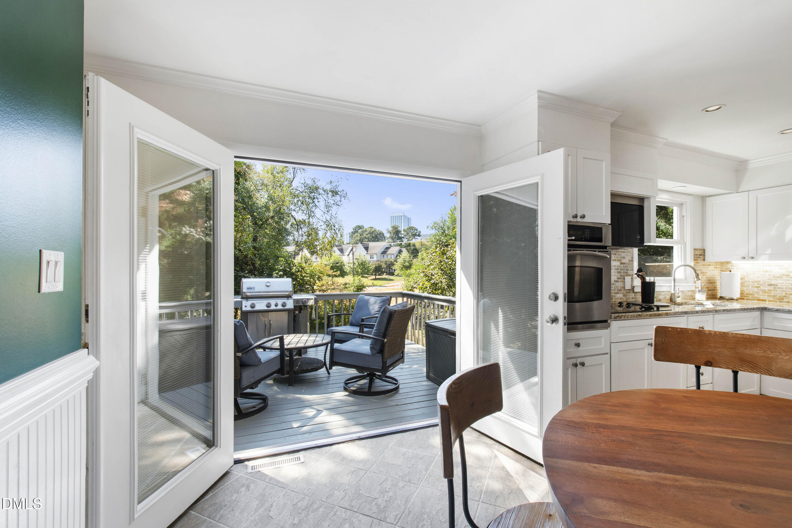 304 Latimer Road Raleigh, NC 27609 - Photo 23 of 42 a kitchen with stainless steel appliances kitchen island granite countertop a refrigerator a stove a dining table and chairs next to a window