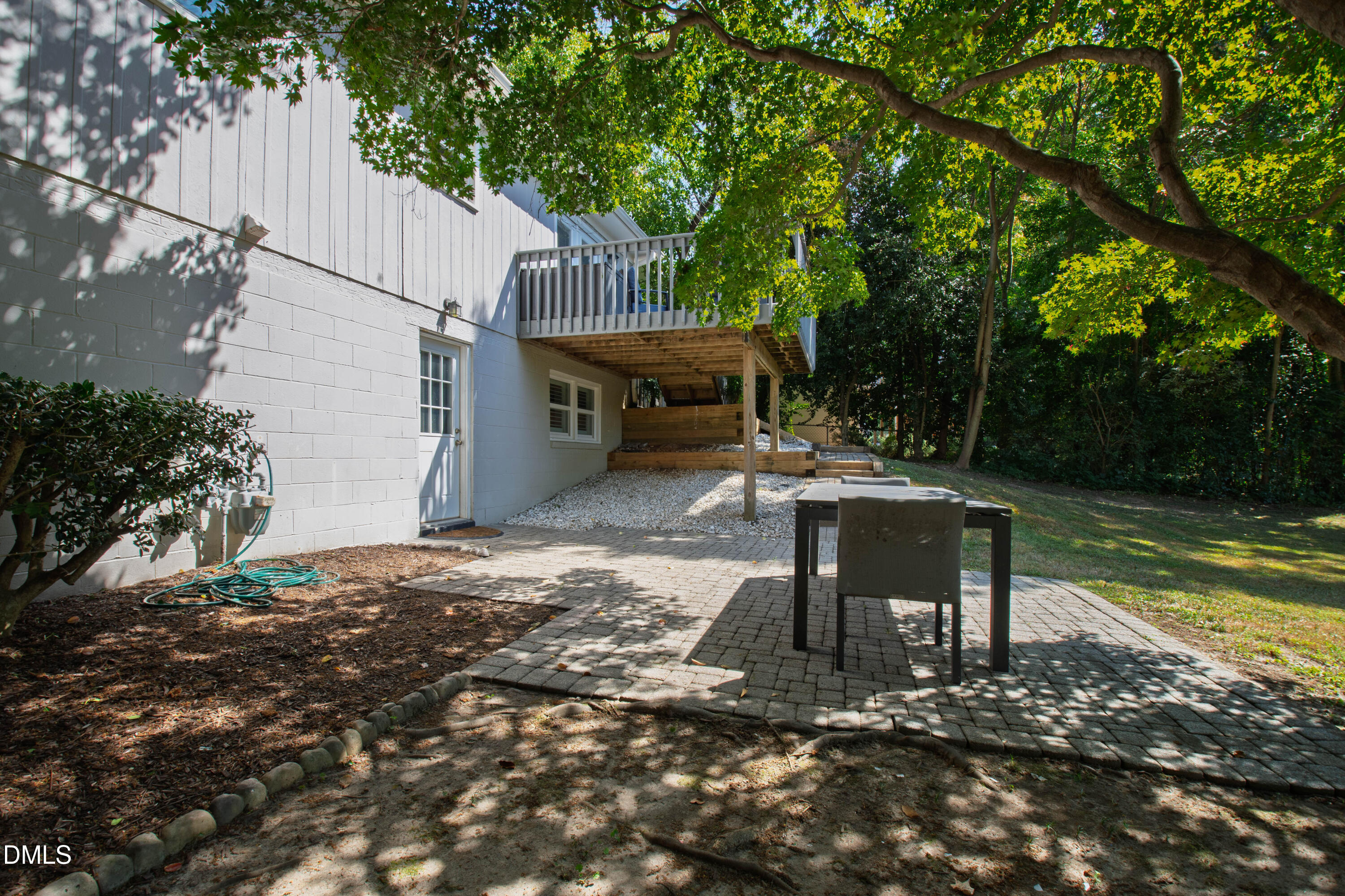 304 Latimer Road Raleigh, NC 27609 - Photo 36 of 42 a view of a patio with table and chairs a fire pit and a large tree