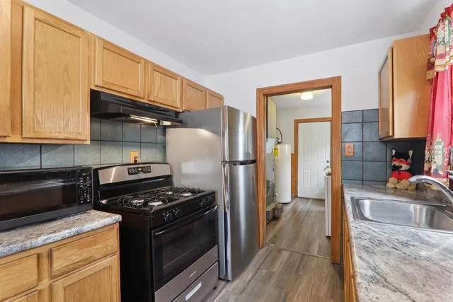 a kitchen with stainless steel appliances granite countertop a stove refrigerator and a microwave