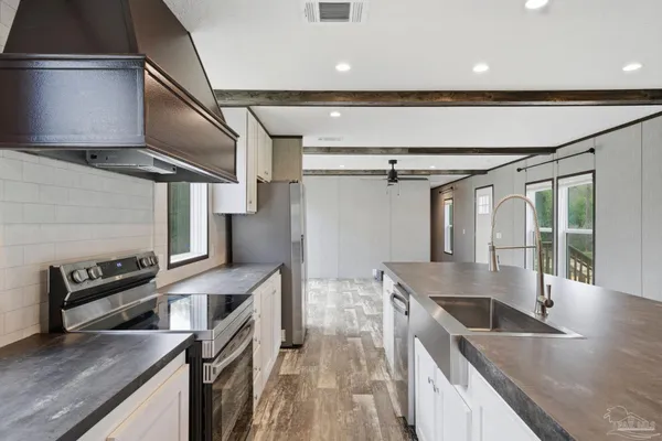 a kitchen with a sink a counter top space and stainless steel appliances
