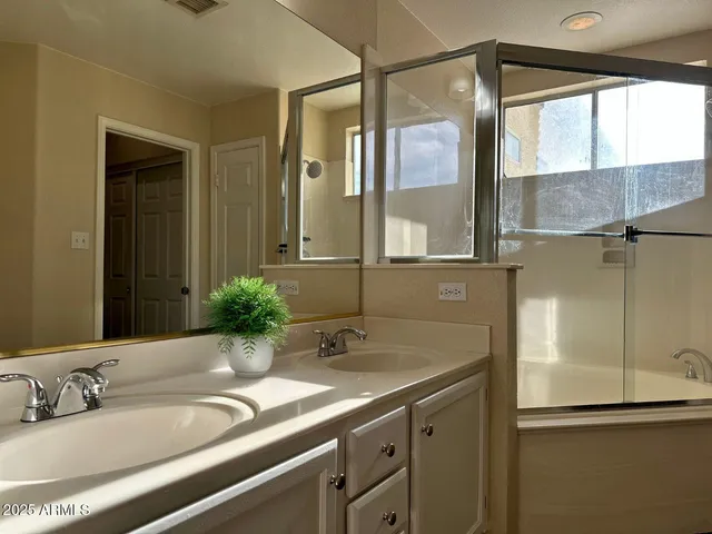 a bathroom with a double vanity sink toilet and a mirror