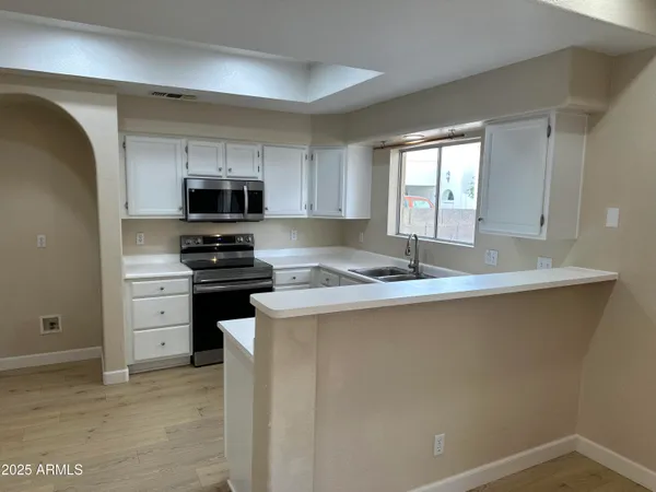 a view of kitchen with sink microwave and refrigerator