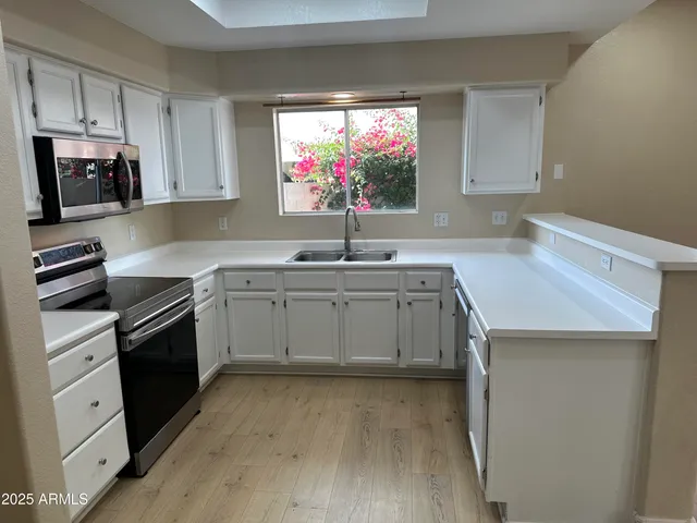 a kitchen with stainless steel appliances a sink stove and microwave