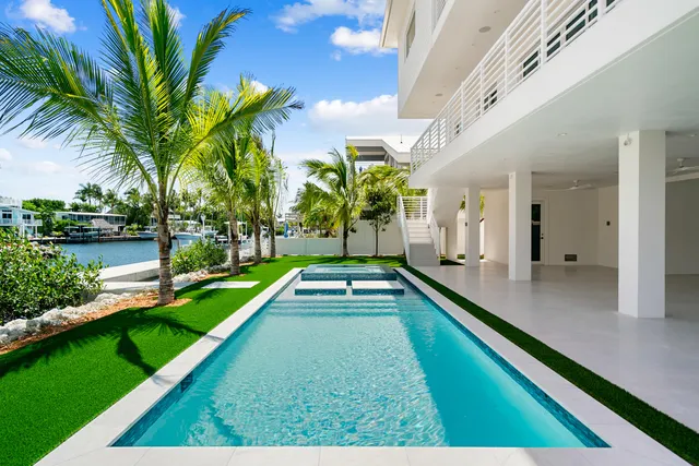 a view of a white house with a yard and potted plants