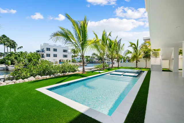 a front view of a house with a yard and potted plants