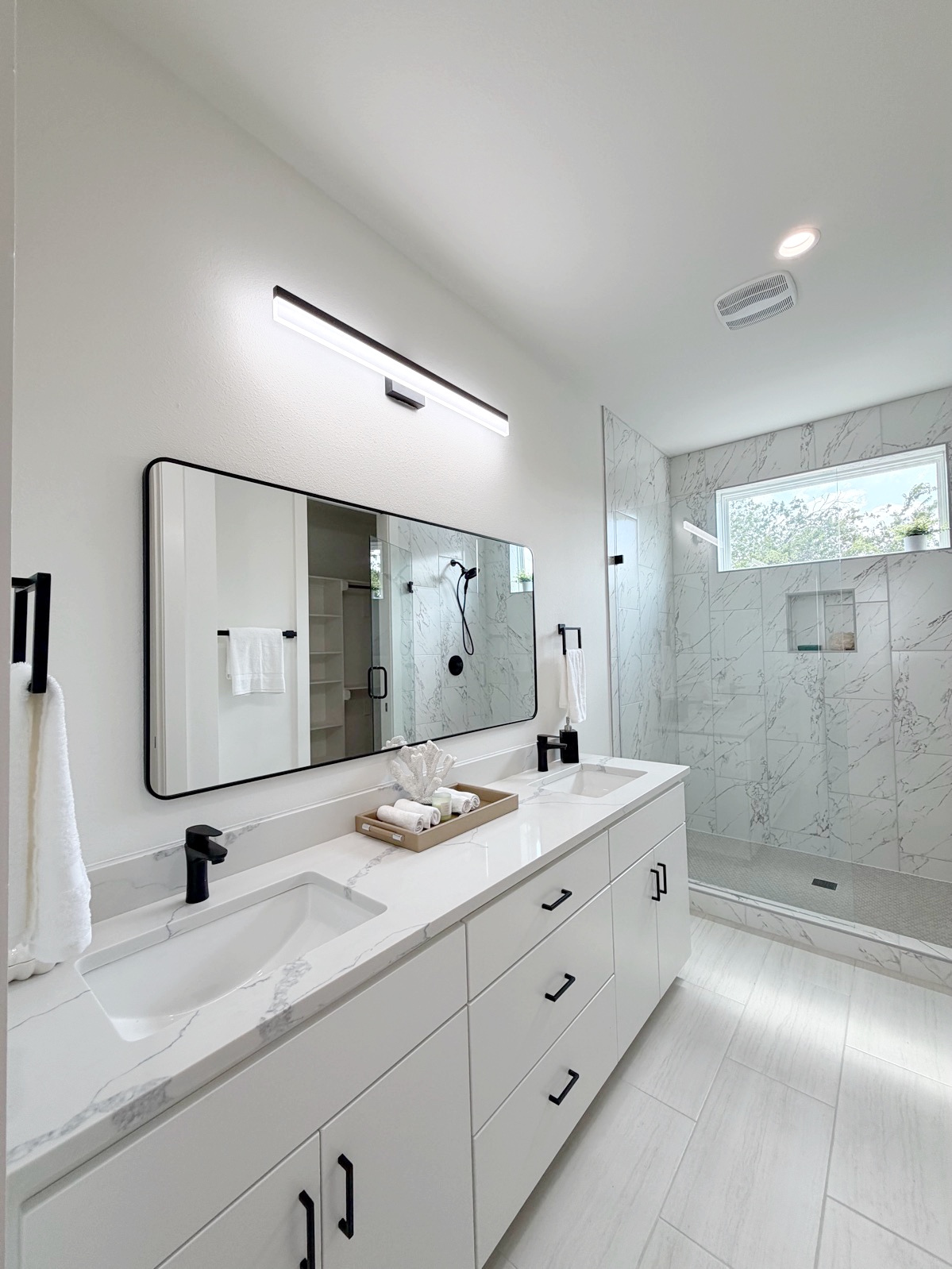 6809 Porter Street, Unit 1 Austin, TX 78741 - Photo 7 of 10 Dual vanities and a spacious shower elevate this modern primary bathroom's function and appeal.