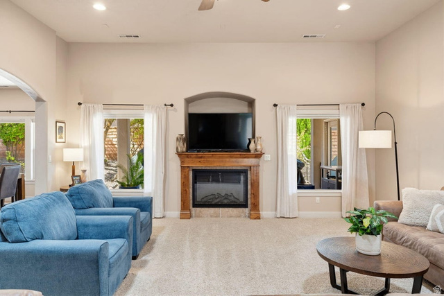 1609 East 10 S Street St. George, UT 84790 - Photo 14 of 68 Living area featuring an arched fireplace niche with a decorative wood mantel, an electric fireplace insert, and stone-look tile surround