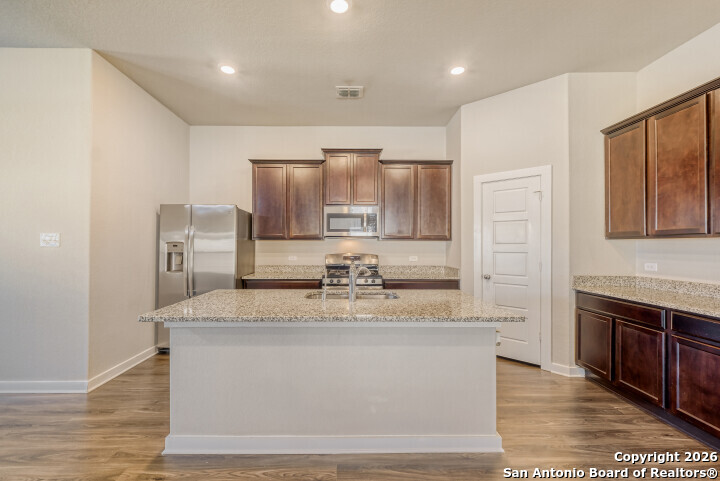 10583 Penelope Way Converse, TX 78109 - Photo 11 of 26 a large kitchen with stainless steel appliances granite countertop a stove a sink and a refrigerator