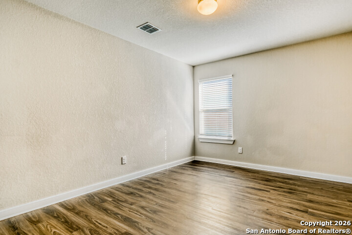 10583 Penelope Way Converse, TX 78109 - Photo 21 of 26 an empty room with wooden floor and windows